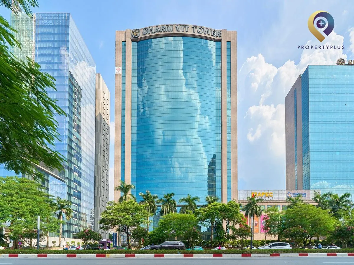 Toàn cảnh tòa nhà Charmvit Tower nhìn từ mặt đường lớn, nổi bật với mặt kính xanh.